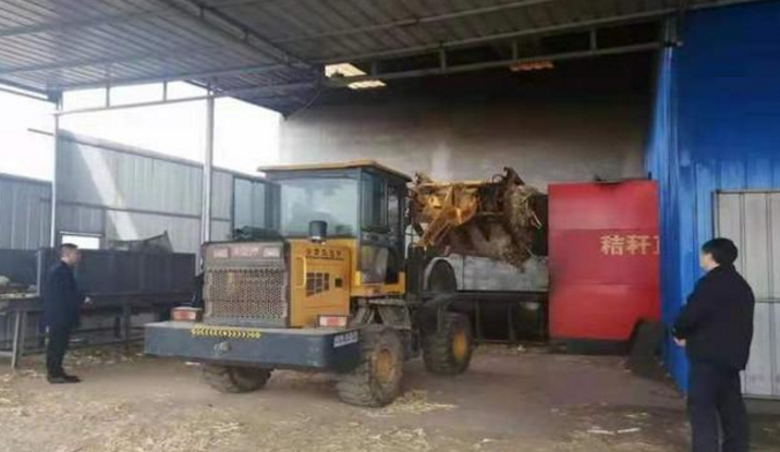 工人在給生物質鍋爐投放秸稈燃料